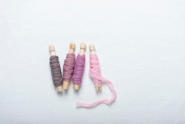 Igła i nici na tkaninie — pastelowy zestaw